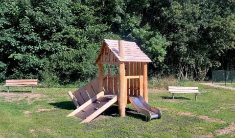 petite cabane de jeux en bois et bancs autour
