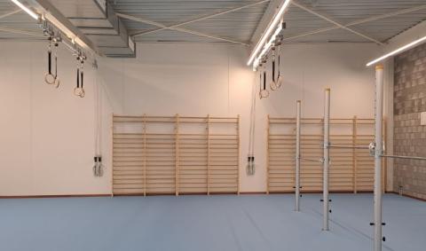 turnzaal met multifunctionele plafond hijsunits voor klimtouwen en turnringen